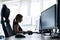 Silhouette of a caucasian business woman typing at a computer. Female employee works overtime. The girl sits at a desk