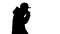 Silhouette Caucasian man in a hat and coat coughing walking.