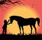 Silhouette of child petting a horse