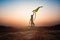 Silhouette of children flying a kite at sunset