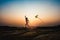 Silhouette of children flying a kite at sunset