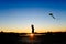 Silhouette of children flying a kite at sunset