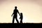 Silhouette of Christian Father Guiding his Young Child by the Hand