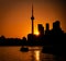 Silhouette of the CN Tower surrounded by water and buildings during a beautiful sunset in Toronto