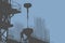 Silhouette of Concrete Pourer Suspended from Construction Crane with Worker Handling the Operation