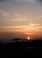 A silhouette of a construction structure in the evening time during the golden hour with a round red Sun. Dehradun Uttarakhand