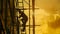 Silhouette of a construction worker on scaffolding at sunset. industrial job site with dynamic sky. concept of