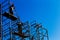 Silhouette of construction workers against sky on scaffolding wi