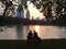 Silhouette Couple Dating in The Park Watching Sunset By The Lake