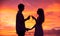 Silhouette of couple drinking champagne at sunset