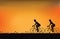 Silhouette of couple driving bike with beautiful sky at sunset.