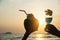 Silhouette couple hand holding cocktail glass and fresh coconut decorated by plumeria flower on beach background