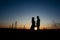 Silhouette of Couple hugging on Power lines background on sunset. Save the planet and electricity. Humanity and