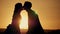 Silhouette couple kissing over sunset background