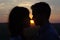 Silhouette couple kissing at sunset