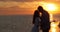 Silhouette of a couple in love on a background of beautiful sunset. Sunset on the beach. Seagull flight.
