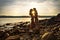 Silhouette of couple in love embracing at the beach against sun