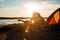 Silhouette of couple sitting near touristic tent and hugging