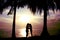 Silhouette couple, woman and man standing and will kissing in front of the sea have coconut tree shadow