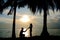 Silhouette couple, woman stand and man sit on the floor and hold her hand for propose her to wedding