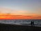 Silhouette couples walking along sunset beach