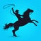 Silhouette of cowboy with lasso riding on horse
