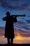 Silhouette of a cowboy pointing a rifle
