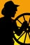 Silhouette of a cowboy and wagon wheel in hand