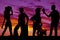 Silhouette of cowboys and cowgirls together in the sunset