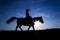 Silhouette cowgirl on horse at sunset in blue 11