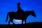 Silhouette cowgirl on horse at sunset in blue 9