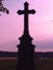 Silhouette of a cross on a background of sky with red clouds, evening twilight