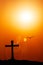 Silhouette of the cross and bird with the sunset flare.