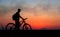 Silhouette of cyclist on the background of red sunset.