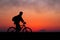 Silhouette of cyclist on the background of red sunset. Biker wit