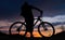 Silhouette of cyclist on the background of sunset.