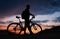 Silhouette of cyclist on the background of sunset.
