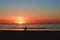 Silhouette of a cyclist on the beach at sunset