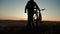 Silhouette cyclist man on a mountain at sunset.