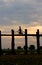 Silhouette of a cyclist on U Bein Bridge at sunset