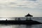 Silhouette of cyclists taking selfie near the sea. Cycling together with friends at the beach with flat sky at stone deck and