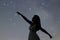 Silhouette of a dancing woman pointing in night sky. Woman Silhouette under starry night, Defocused Milky Way galaxy.