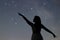 Silhouette of a dancing woman pointing in night sky. Woman Silhouette under starry night, Defocused Milky Way galaxy.