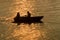 Silhouette of dating couple, recreational boat on lake at sunset