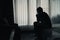 Silhouette depressed man sadly sitting on the bed in the bedroom
