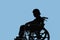 Silhouette of Disabled and dejected elderly woman sitting