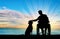 Silhouette of a disabled man in a wheelchair stroking his dog