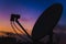 silhouette of dishes against sky in sunset