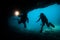Silhouette divers in a cave