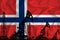 Silhouette of drilling rigs and oil derricks on the background of the flag of Norway. Oil and gas industry. The concept of oil